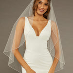 Fingertip Veil with Pearls and Sequins Woman wearing a wedding dress with a sheer veil against a neutral background