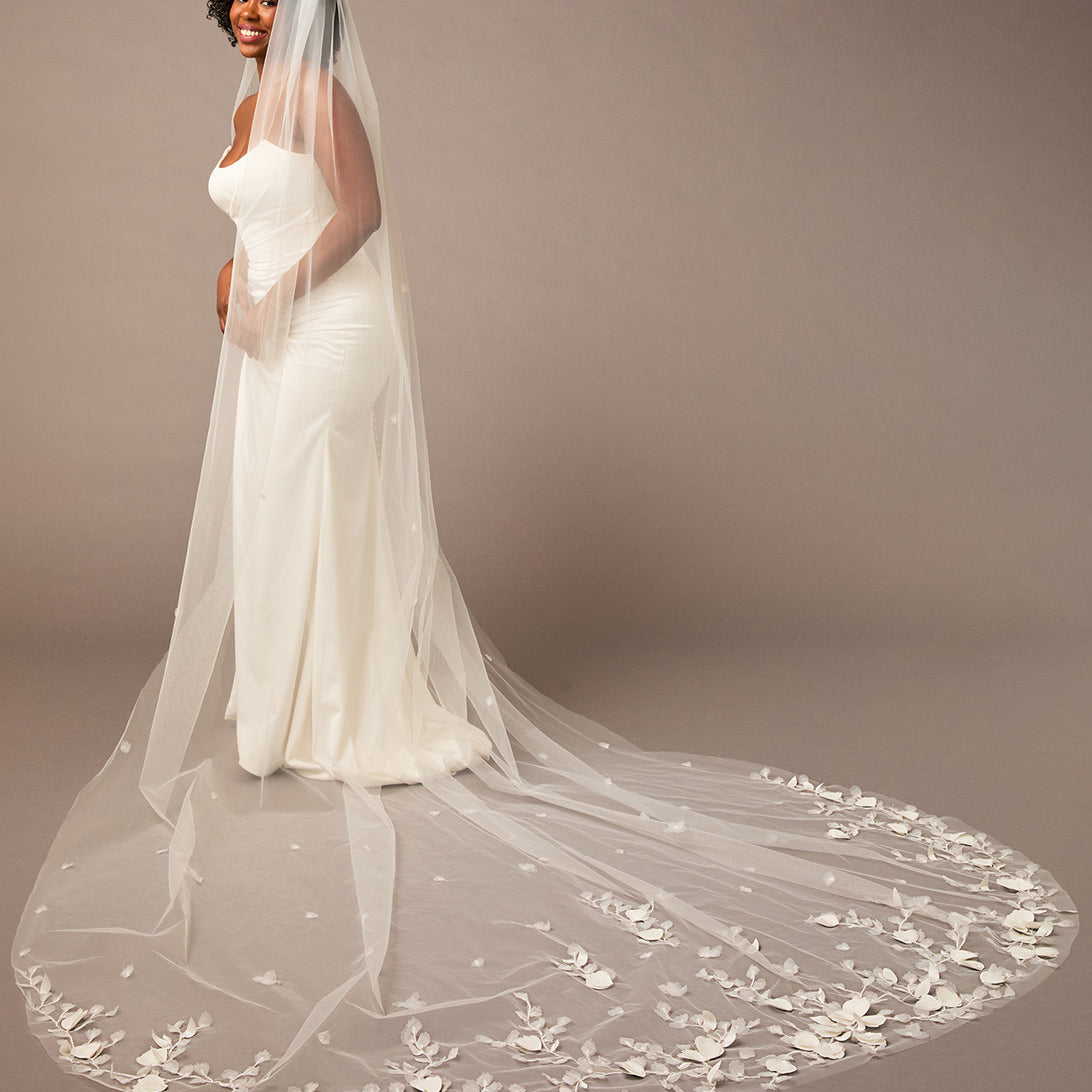 Woman wearing a white wedding dress with a long, floral-embellished veil on a brown background 3D Flowers and Leaves Bridal Royal Cathedral Veil