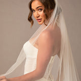 Woman wearing a white wedding dress with a long veil against a brown background Royal Cathedral Bridal Veil Floral Embroidered Lace - Cassandra Lynne