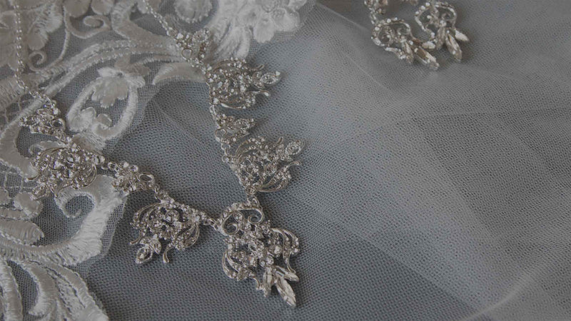 Silver bridal headpiece with intricate designs on a soft gray background