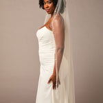 Pearl Wave Waltz Length Bridal Veil Woman wearing a wedding dress with a veil against a plain background