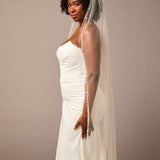 Pearl Wave Waltz Length Bridal Veil Woman wearing a wedding dress with a veil against a plain background