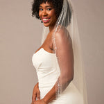 Pearl Wave Waltz Length Bridal Veil Woman wearing a wedding dress with a veil against a plain background