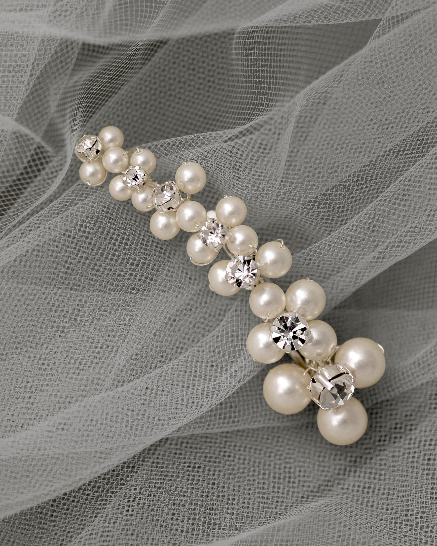 Pearl hair clip with crystals on a gray fabric background