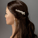 Woman with a pearl hair accessory against a gray background