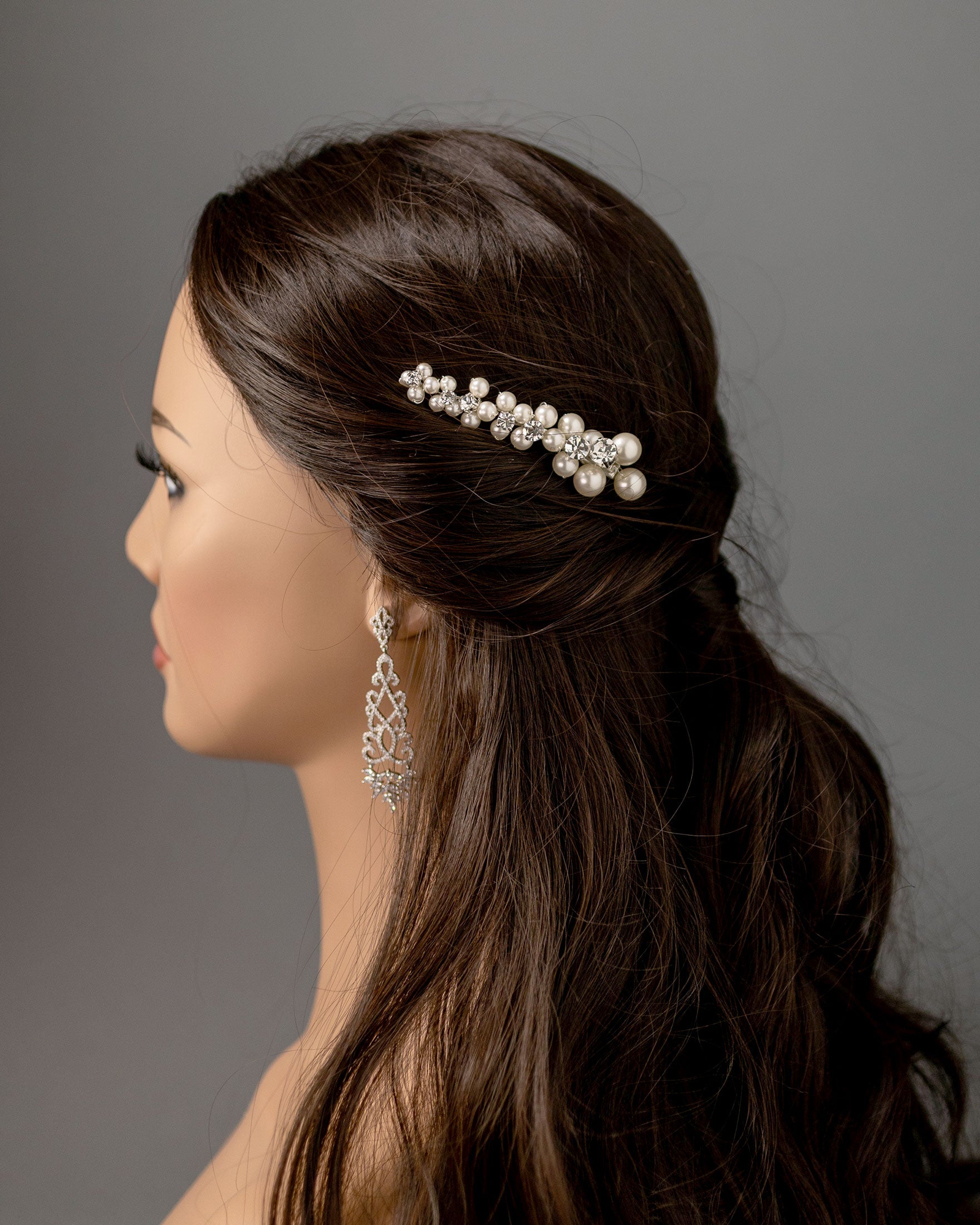 Woman with a pearl hair accessory against a gray background