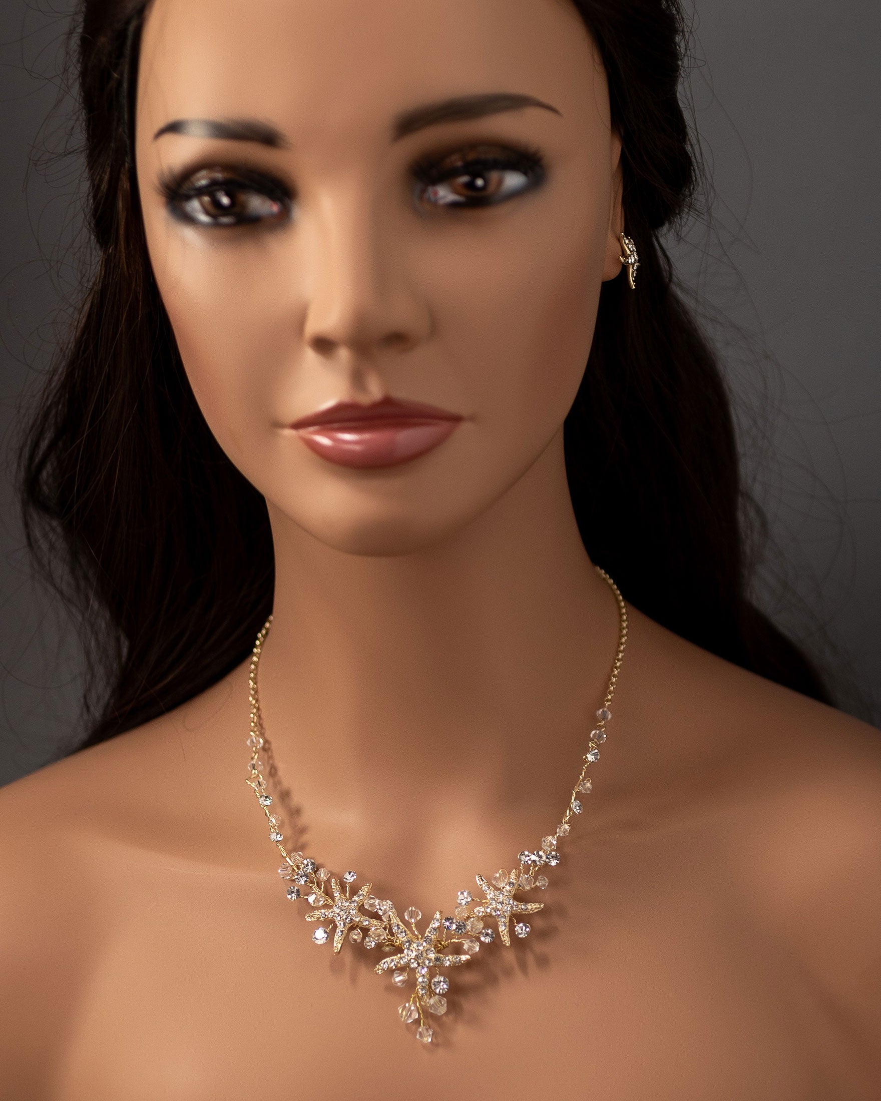 Three crystal covered starfish are surrounded by crystal stones and beads for a sparkly look. Matching bracelet here.