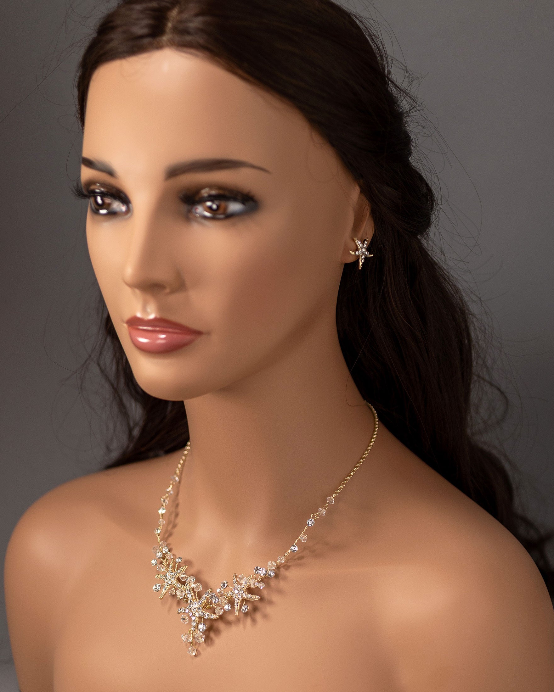 Three crystal covered starfish are surrounded by crystal stones and beads for a sparkly look. Matching bracelet here.
