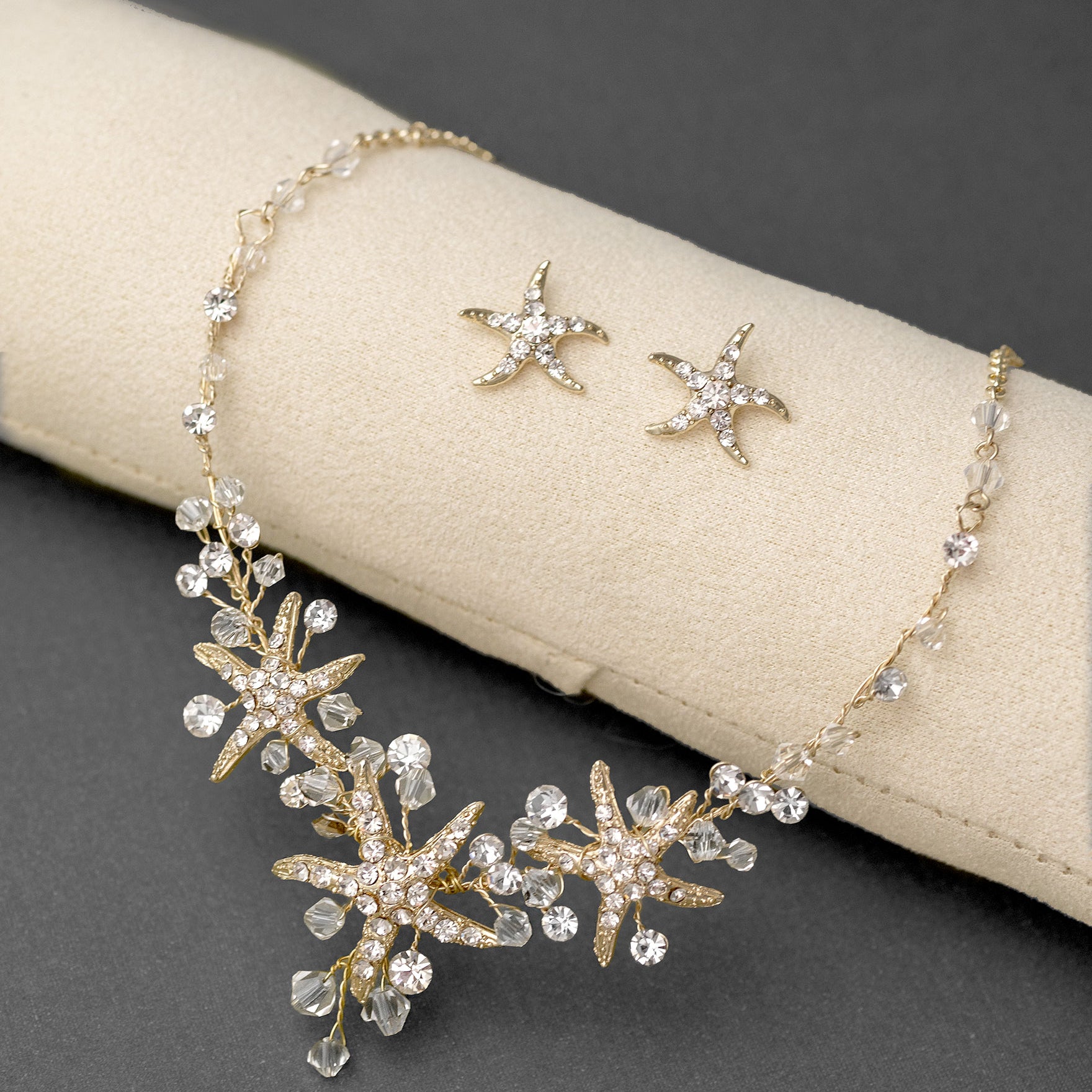 Three crystal covered starfish are surrounded by crystal stones and beads for a sparkly look. Matching bracelet here.