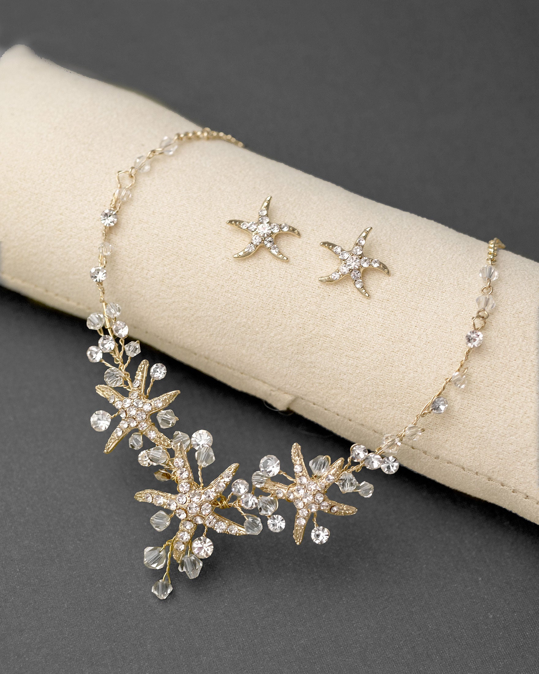 Three crystal covered starfish are surrounded by crystal stones and beads for a sparkly look. Matching bracelet here.