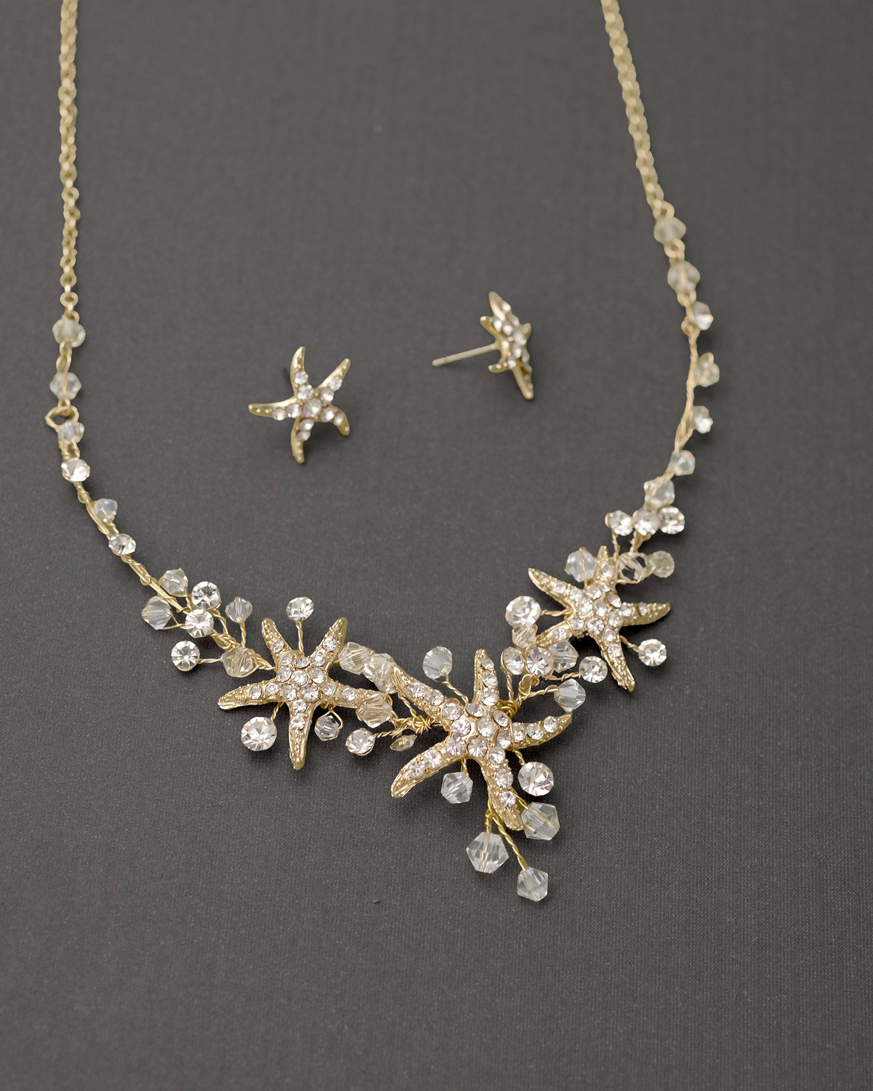 Three crystal covered starfish are surrounded by crystal stones and beads for a sparkly look. Matching bracelet here.