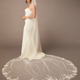 Cathedral Luxe Tulle Lace Wedding Veil Bridal gown with a long, elegant veil on a plain background