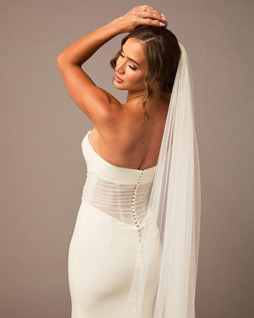 Cathedral Luxe Tulle Lace Wedding Veil Woman wearing a wedding dress with a long veil against a plain background