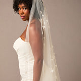 Cathedral Veil with Vine Appliques Woman wearing a wedding dress with a long veil against a plain background