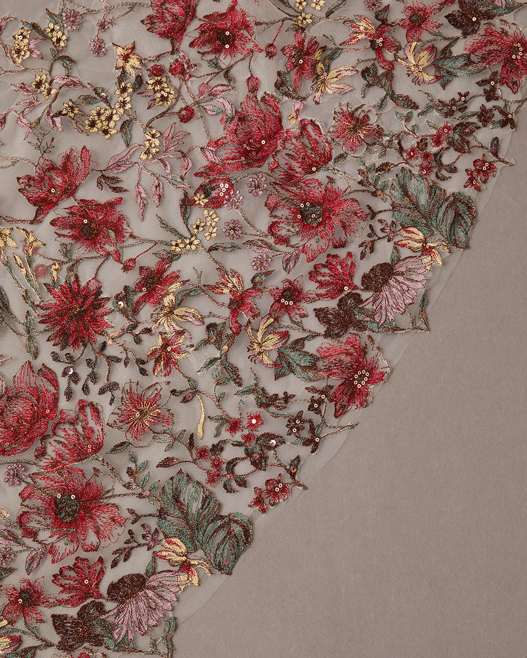 Cathedral Wedding Veil with Burgundy Flower Lace Close-up of intricate floral embroidery with red and gold flowers on a textured fabric background.