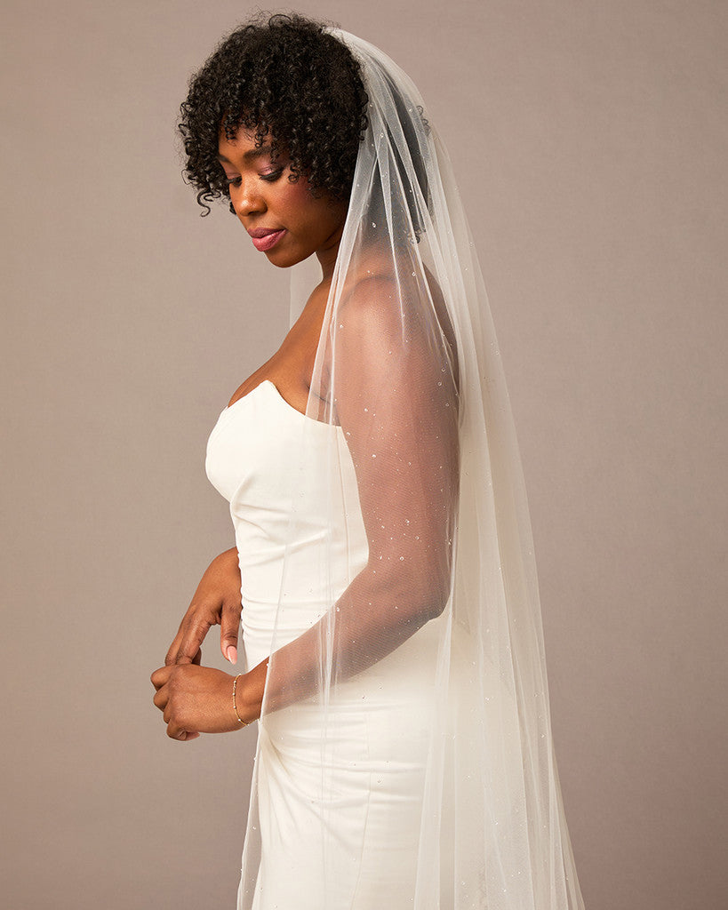 Royal Veil with Raindrop Scatter Woman wearing a wedding dress with a veil against a plain background