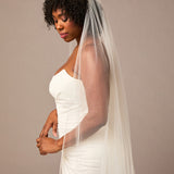Royal Veil with Raindrop Scatter Woman wearing a wedding dress with a veil against a plain background
