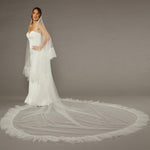 Luxe Tulle Ruffle Edge Two Layer Mantilla Cathedral Bridal Veil Woman wearing a wedding dress with a long veil on a gray background