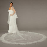 Luxe Tulle Ruffle Edge Two Layer Mantilla Cathedral Bridal Veil Woman wearing a wedding dress with a long veil on a gray background