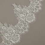 Two Layer Chantilly Lace Cathedral Bridal Veil Close-up of white lace fabric on a gray background