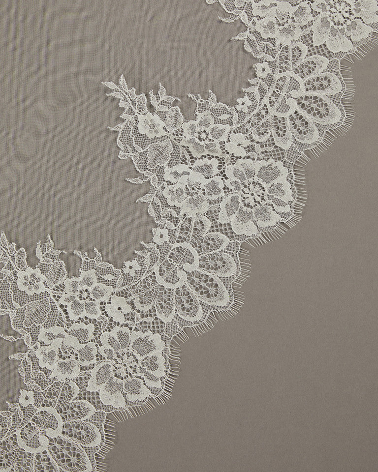 Two Layer Chantilly Lace Cathedral Bridal Veil Close-up of white lace fabric on a gray background
