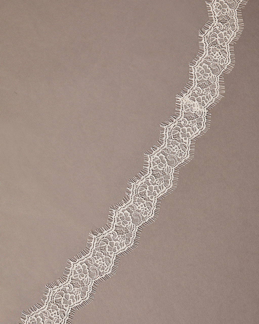 Double Eyelash Lace Cathedral Mantilla Veil Lace trim on a brown background