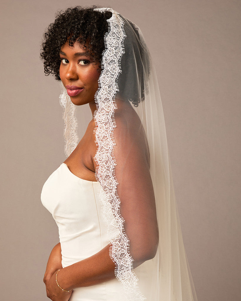  Double Eyelash Lace Cathedral Mantilla VeilWoman wearing a white wedding dress with a lace veil against a plain background