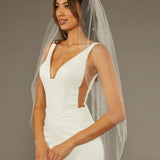 Fingertip Veil with Scattered Clusters of Crystal Beads Woman wearing a wedding dress with a veil against a brown background