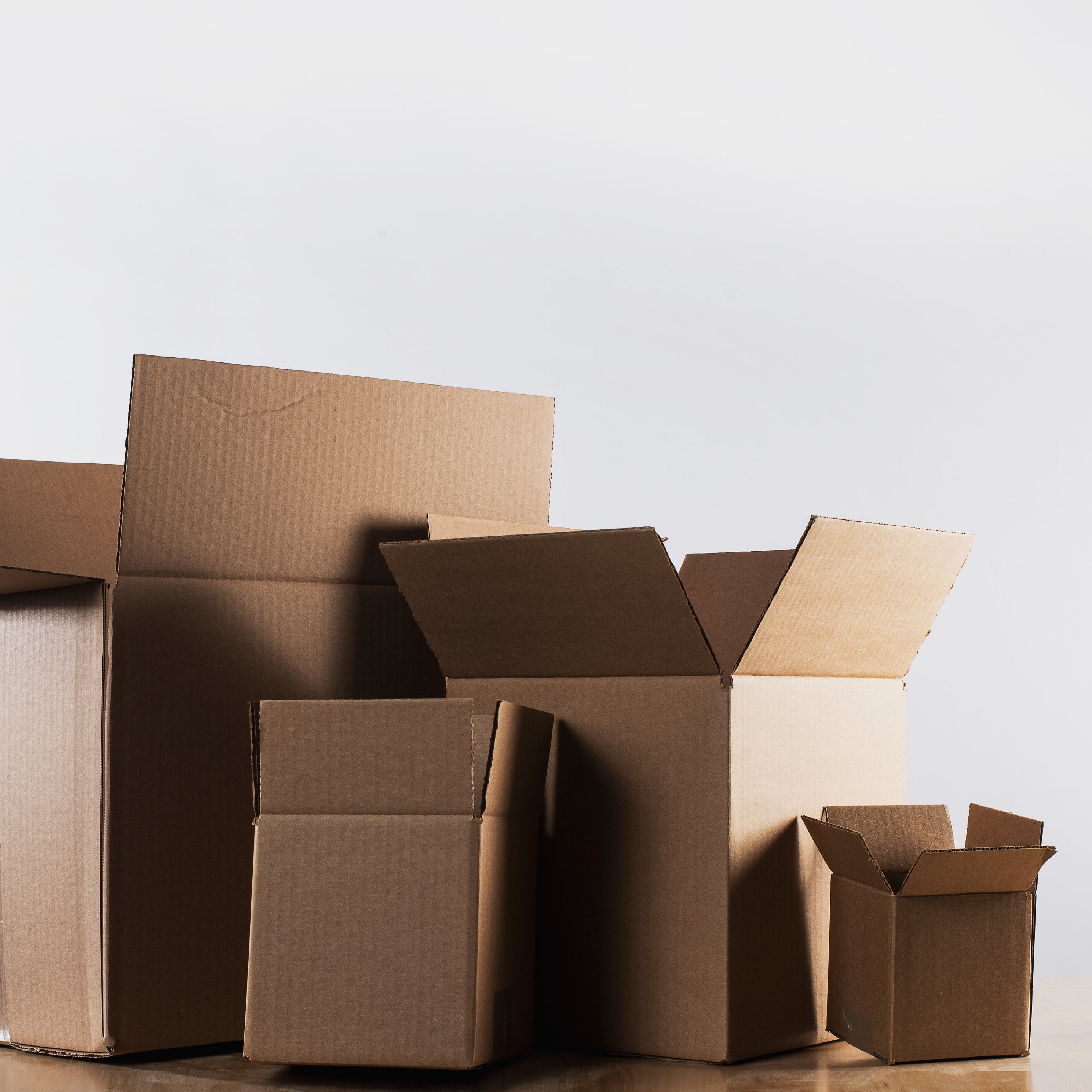 Stack of cardboard boxes of various sizes on a light background