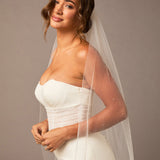 Fingertip Veil with Raindrop Scatter Woman wearing a strapless dress with a veil against a plain background