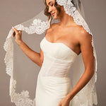 Woman wearing a white wedding dress with a lace veil against a neutral background Mantilla Veil with Wide Flower Chantilly Lace