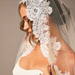 Woman wearing a lace veil with a plain background Mantilla Cathedral Veil with Wide Flower Chantilly Lace
