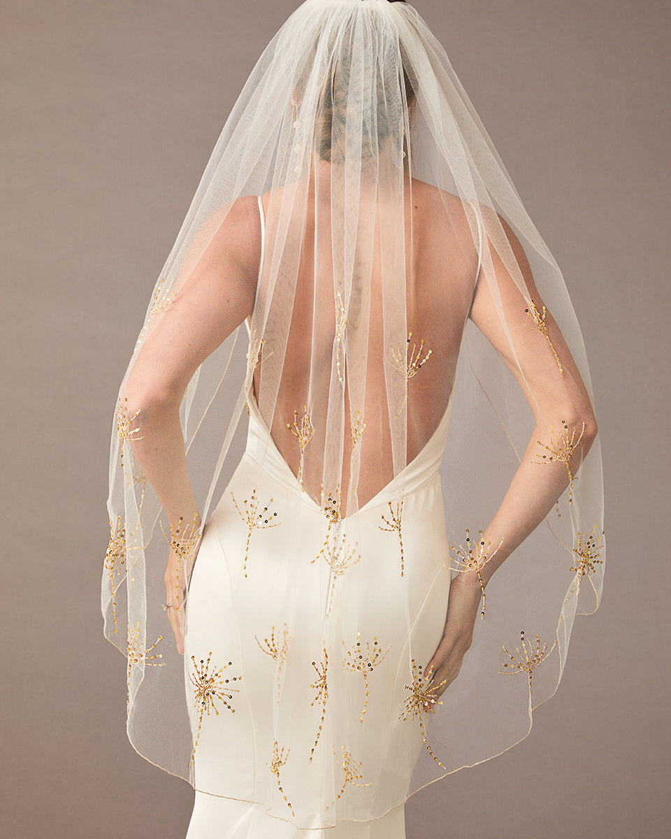 Fingertip Veil with Gold Sequined Dandelion Accents wedding dress with a sheer veil featuring gold embroidery on a plain background