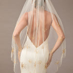 Fingertip Veil with Gold Sequined Dandelion Accents wedding dress with a sheer veil featuring gold embroidery on a plain background