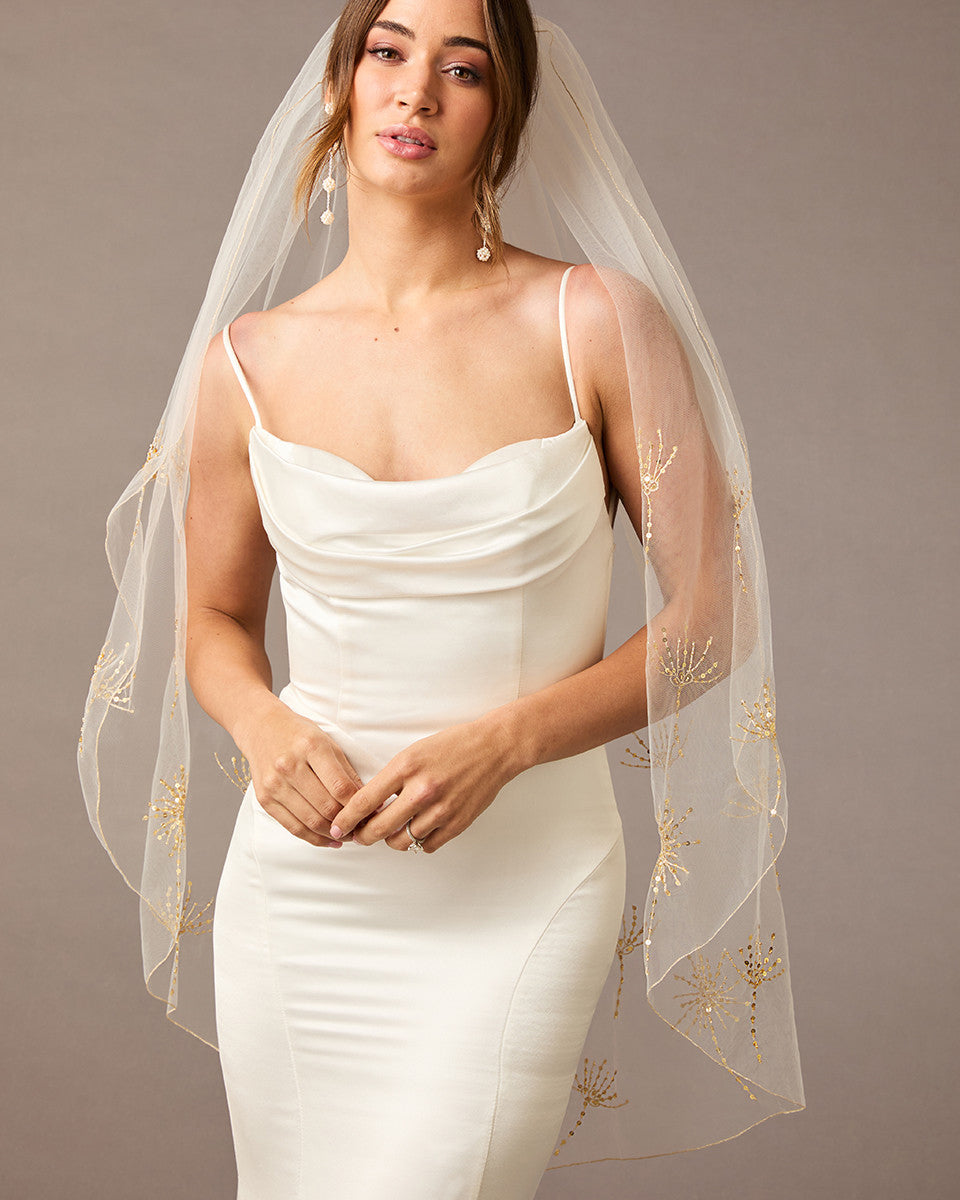 Fingertip Veil with Gold Sequined Dandelion Accents Woman wearing a wedding dress with a sheer veil against a neutral background