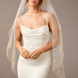 Fingertip Veil with Gold Sequined Dandelion Accents Woman wearing a wedding dress with a sheer veil against a neutral background