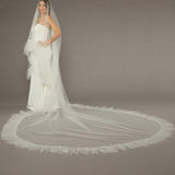 Luxe Tulle Ruffle Edge Two Layer Mantilla Cathedral Bridal Veil Bride in a wedding dress with a long veil on a plain background