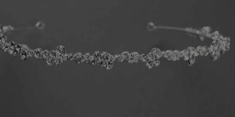 Silver headband with small crystals on a dark background