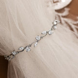 CZ Bracelet Marquise and Round Vine A delicate silver vinebracelet adorned with clear cz, draped over a soft beige tulle fabric.
