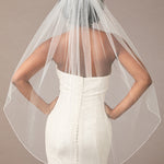 Fingertip Bridal Veil with Iridescent Rhinestones Woman wearing a wedding dress with a sheer veil against a neutral background