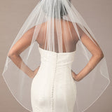 Fingertip Bridal Veil with Iridescent Rhinestones Woman wearing a wedding dress with a sheer veil against a neutral background