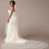 Woman wearing a wedding dress with a long veil against a plain background - Royal Cathedral Bridal Veil with Iridescent Rhinestones- Cassandra Lynne