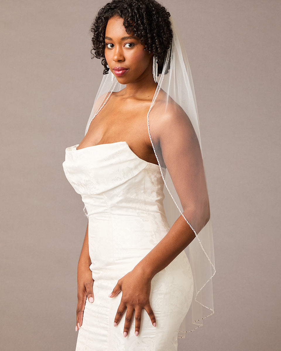 Fingertip Bridal Veil with Iridescent Rhinestones Woman wearing a strapless dress with a veil against a plain background