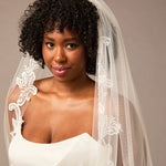 Cathedral Bridal Veil with Venetian Style Lace Woman wearing a wedding dress with a lace veil against a neutral background