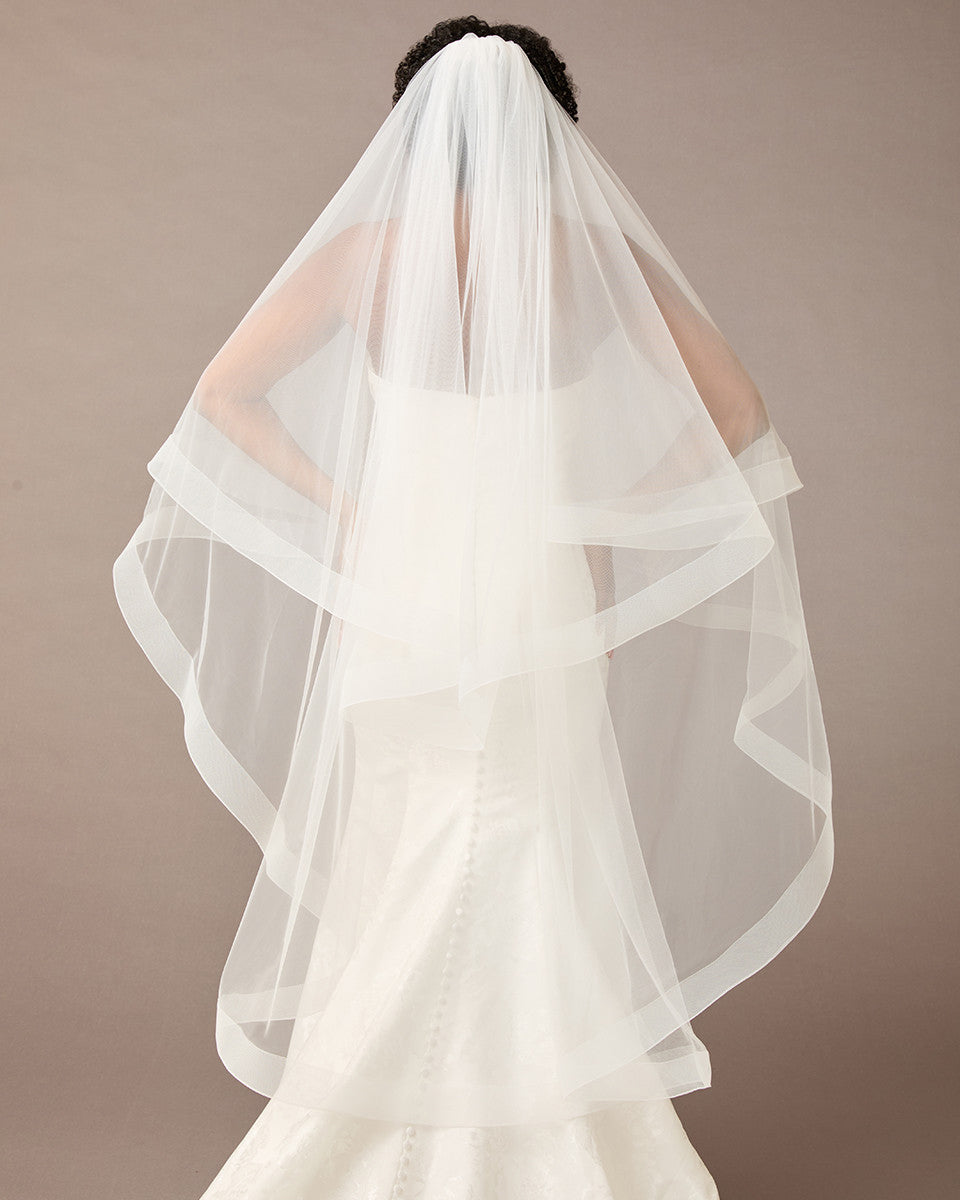 Two Inch Horsehair Trim Waltz Veil  wedding dress with a long veil on a plain background