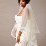Two Inch Horsehair Trim Waltz Veil Woman wearing a wedding dress with a veil against a plain background