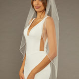 Square Sequins Fingertip Bridal Veil Woman wearing a  wedding dress with a sheer veil against a brown background