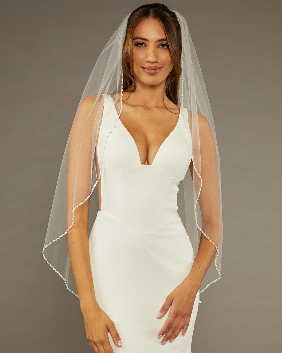 Square Sequins Fingertip Bridal Veil Woman wearing a wedding dress with a sheer veil against a brown background