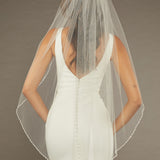 Square Sequins Fingertip Bridal Veil Bride wearing a dress with a sheer veil against a brown background