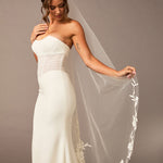 Lace Beaded Waltz Mantilla Wedding Veil Woman wearing a strapless white wedding dress with a floral veil against a plain background